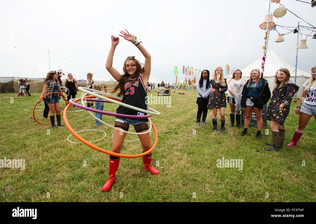 Festival goers watch a young woman having fun  hula hooping at the Y Not music festival in Derbyshire England UK Stock Photo