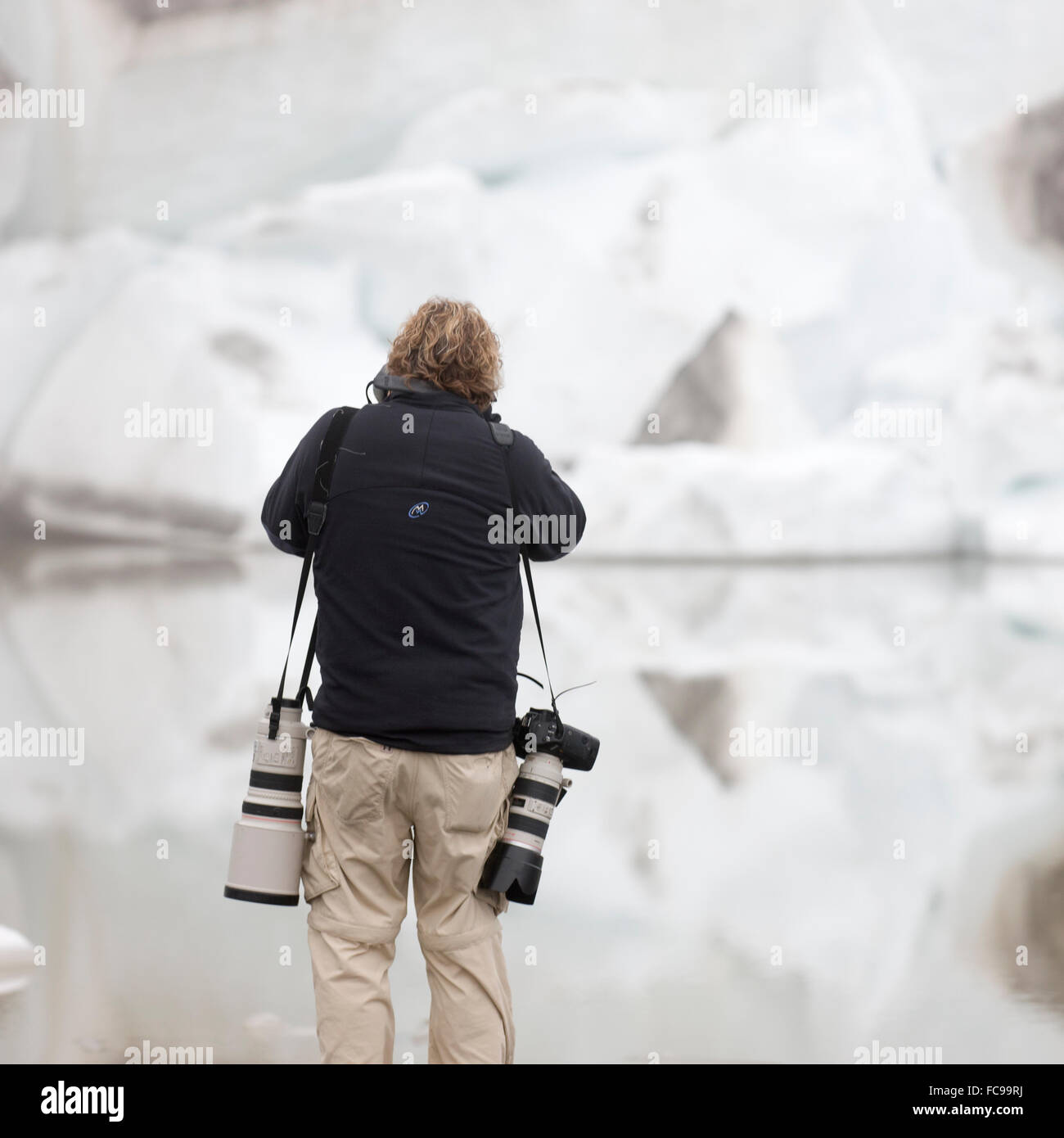 Photographer by glacial ice, Eyjafjallajokull Glacier, Iceland Stock Photo