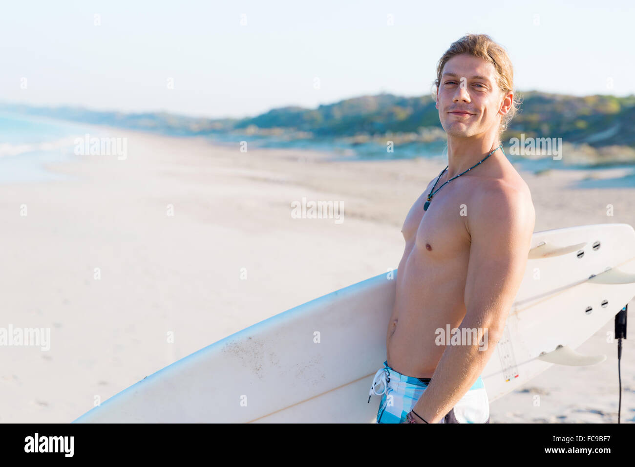 A young surfer with his board on the beach Stock Photo - Alamy