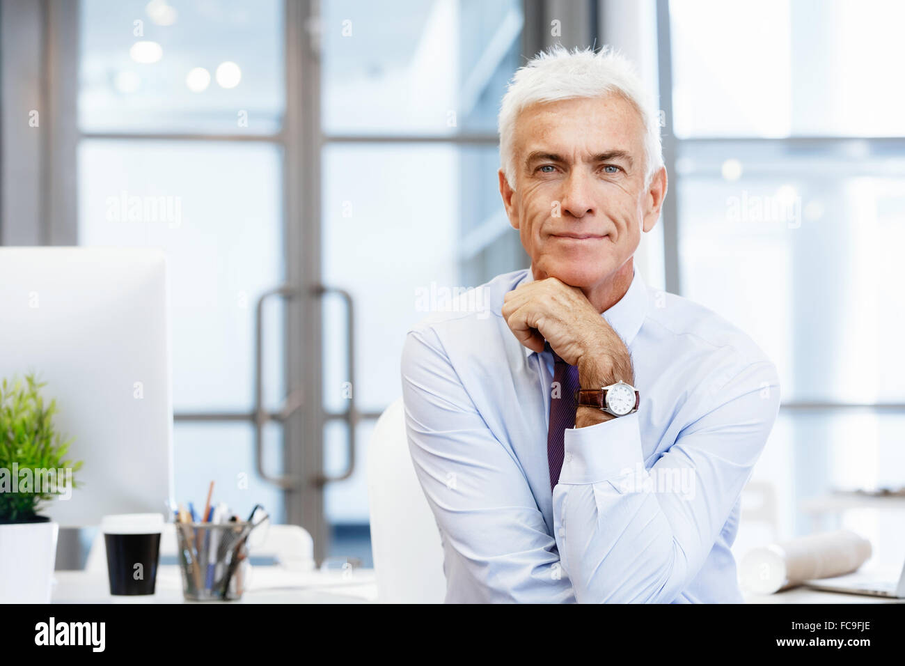 Businessman standing in office smiling at camera Stock Photo - Alamy