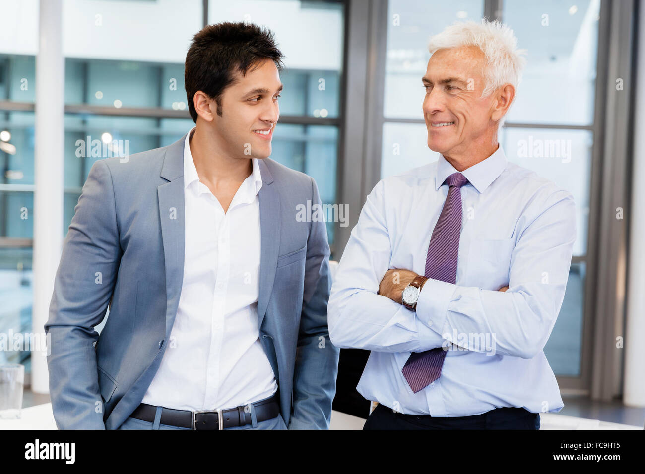 Two businessmen in office standing Stock Photo - Alamy