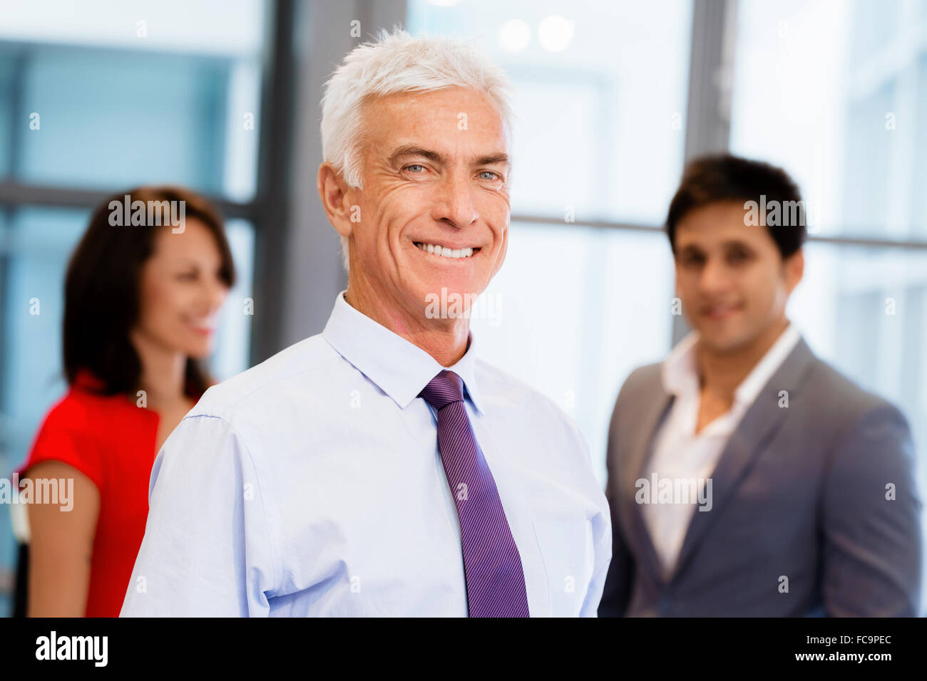 Group of businesspeople in office standing Stock Photo - Alamy