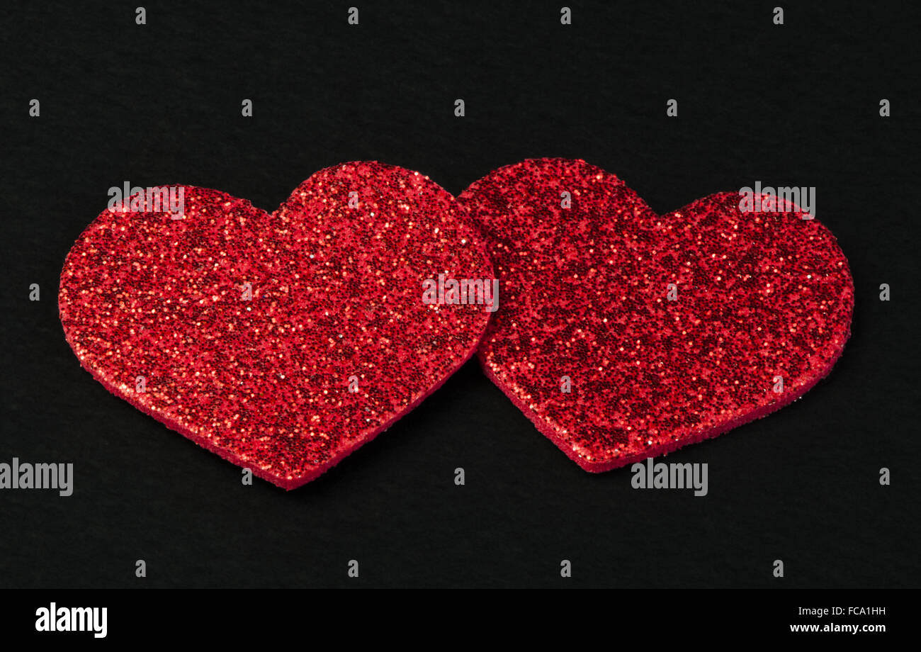 Red shiny hearts on black background Stock Photo - Alamy