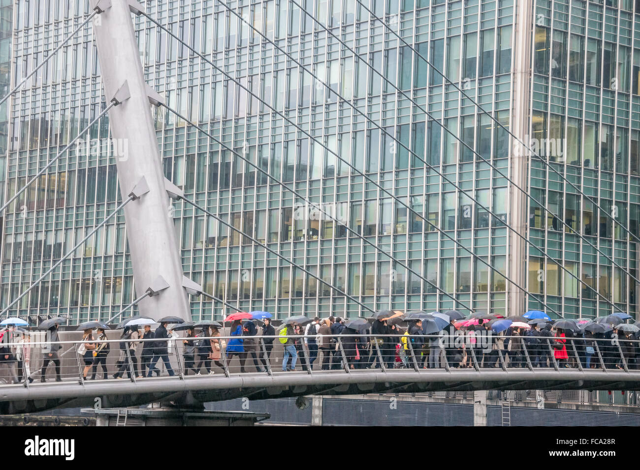 Canary Wharf, London, UK - 03 November 2015 - Commuters walking to work with colourful umbrellas under the rain, no DLR Stock Photo