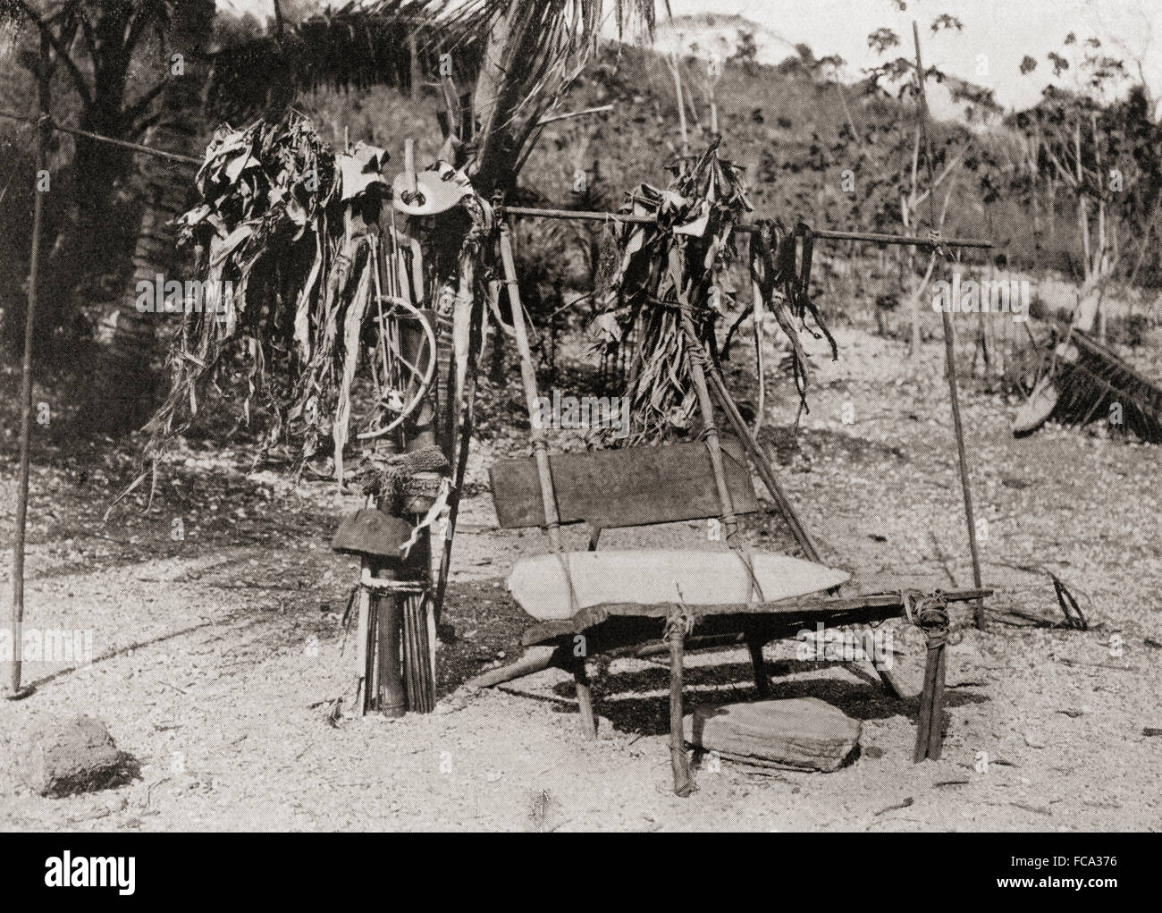 A death chair from Koita, Papua New Guinea, Oceania.  The body of a dead man was placed in a sitting position on this prior to burial and his two nearest relatives sat on either side of it, then after an hour's drum beating and dirge singing the dead man's chief possessions were broken up and placed by the chair.  After a 19th century photograph. Stock Photo