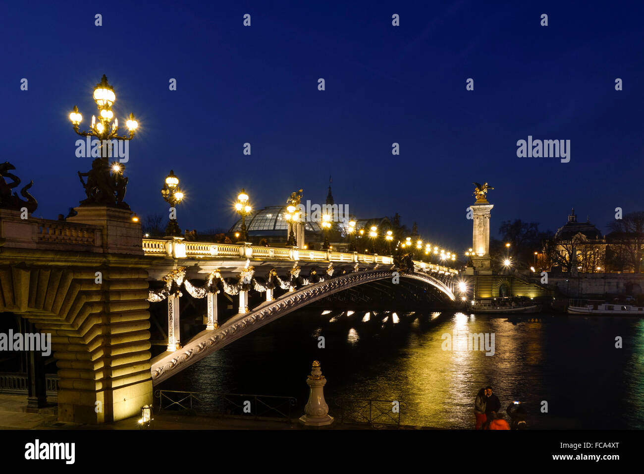The Pont Alexandre III, arch bridge in Paris at night, Grand Palais behind, France. Stock Photo