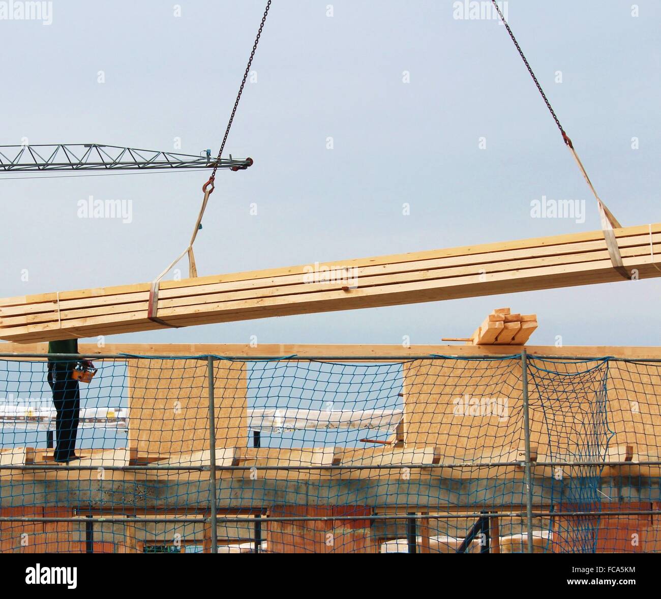 Crane is transporting wood bars Stock Photo