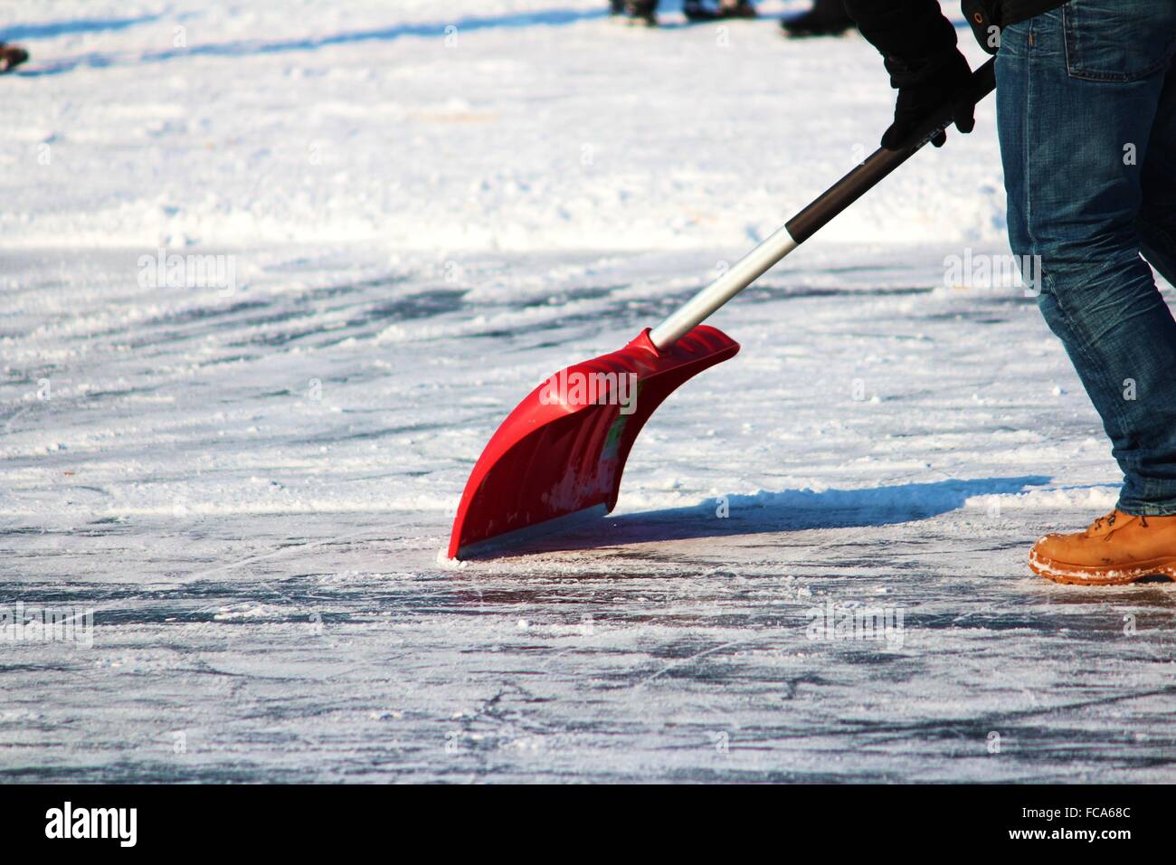 Snow shovel on ice Stock Photo