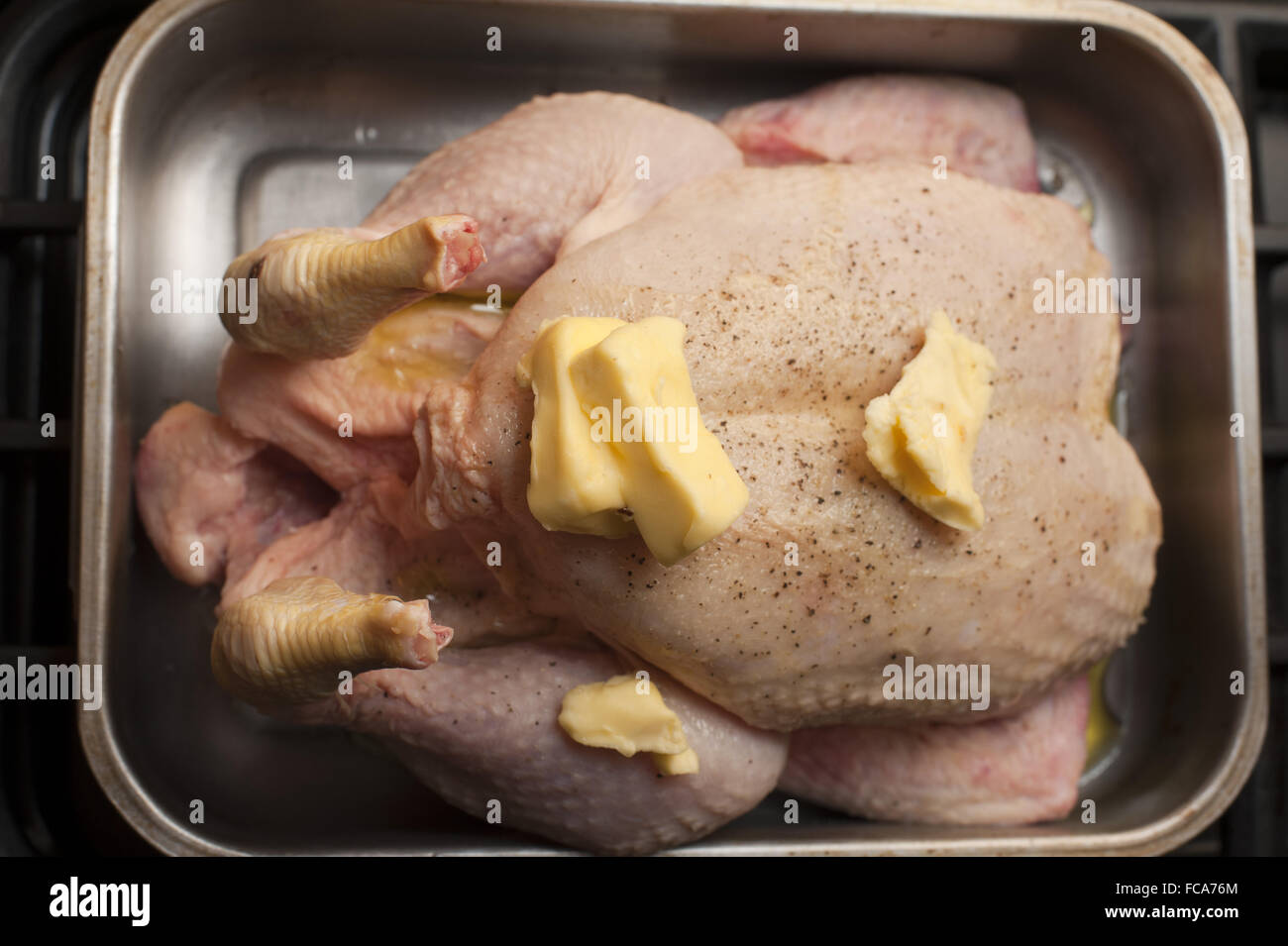 Preparing a raw chicken for roasting Stock Photo