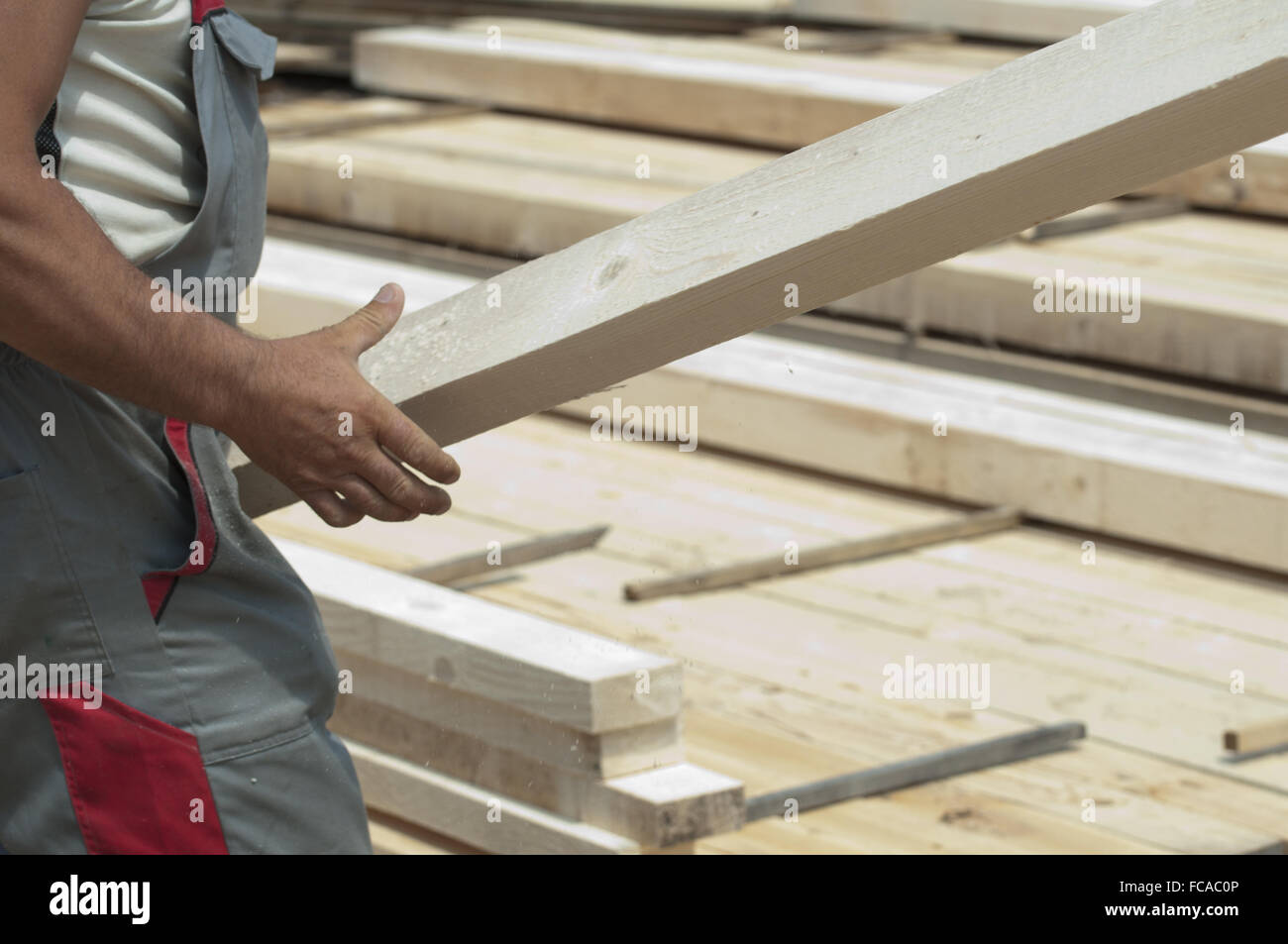 Worker moves a wooden beam Stock Photo - Alamy