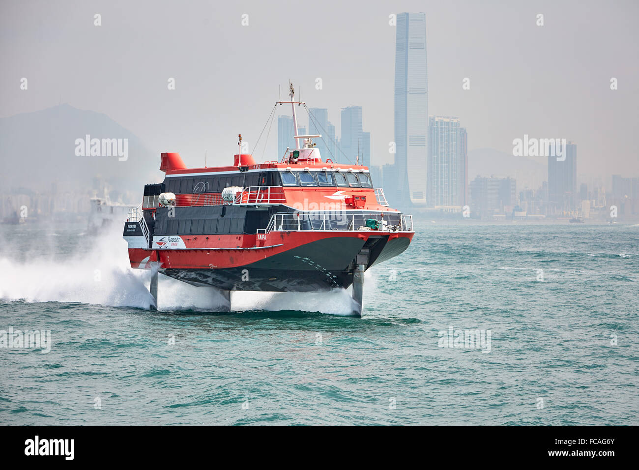 A TurboJET hydrofoil ferry leaves Hong Kong to make its way to Macau with Hong Kong's cityscape in the background. Stock Photo