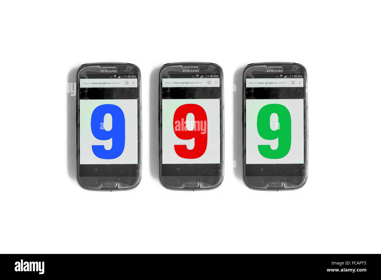 999 written on the screen of smartphones photographed against a white background. Stock Photo