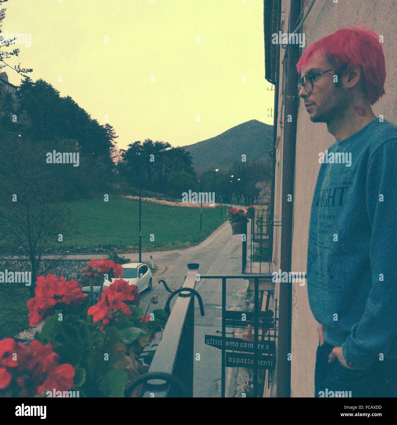 Side View Of Young Man Standing On Balcony Stock Photo