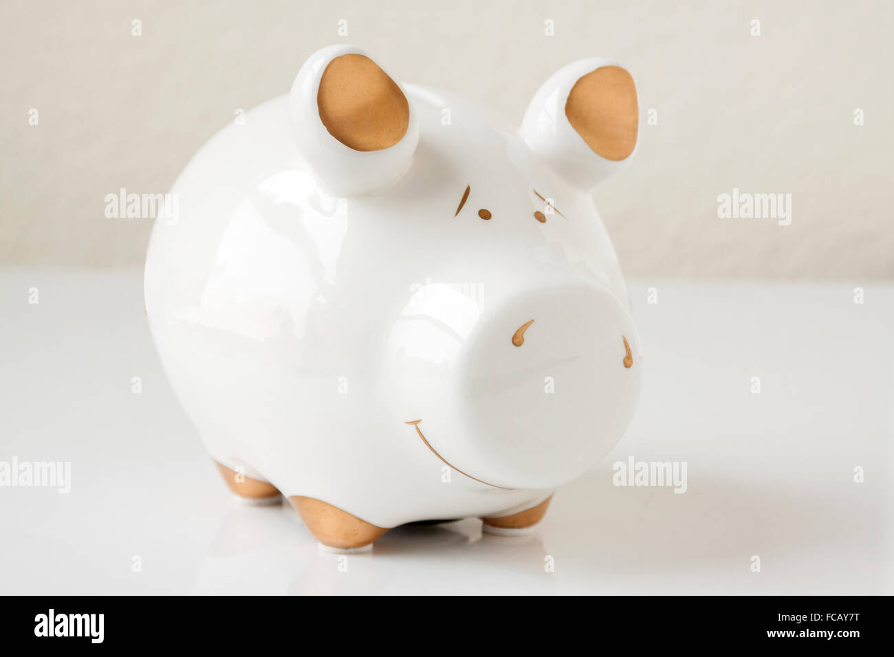 A white and gold piggy bank on a white background Stock Photo - Alamy