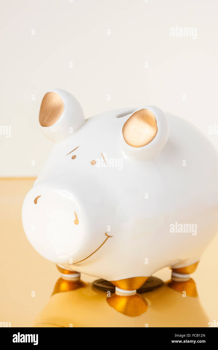 A white and gold piggy bank on a white and gold background Stock Photo ...