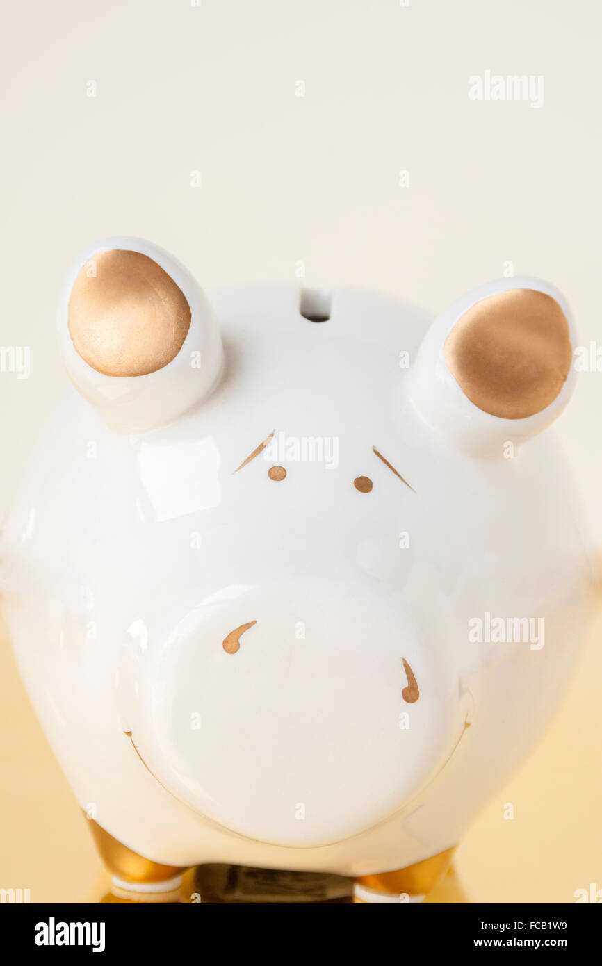 A white and gold piggy bank on a white and gold background Stock Photo ...