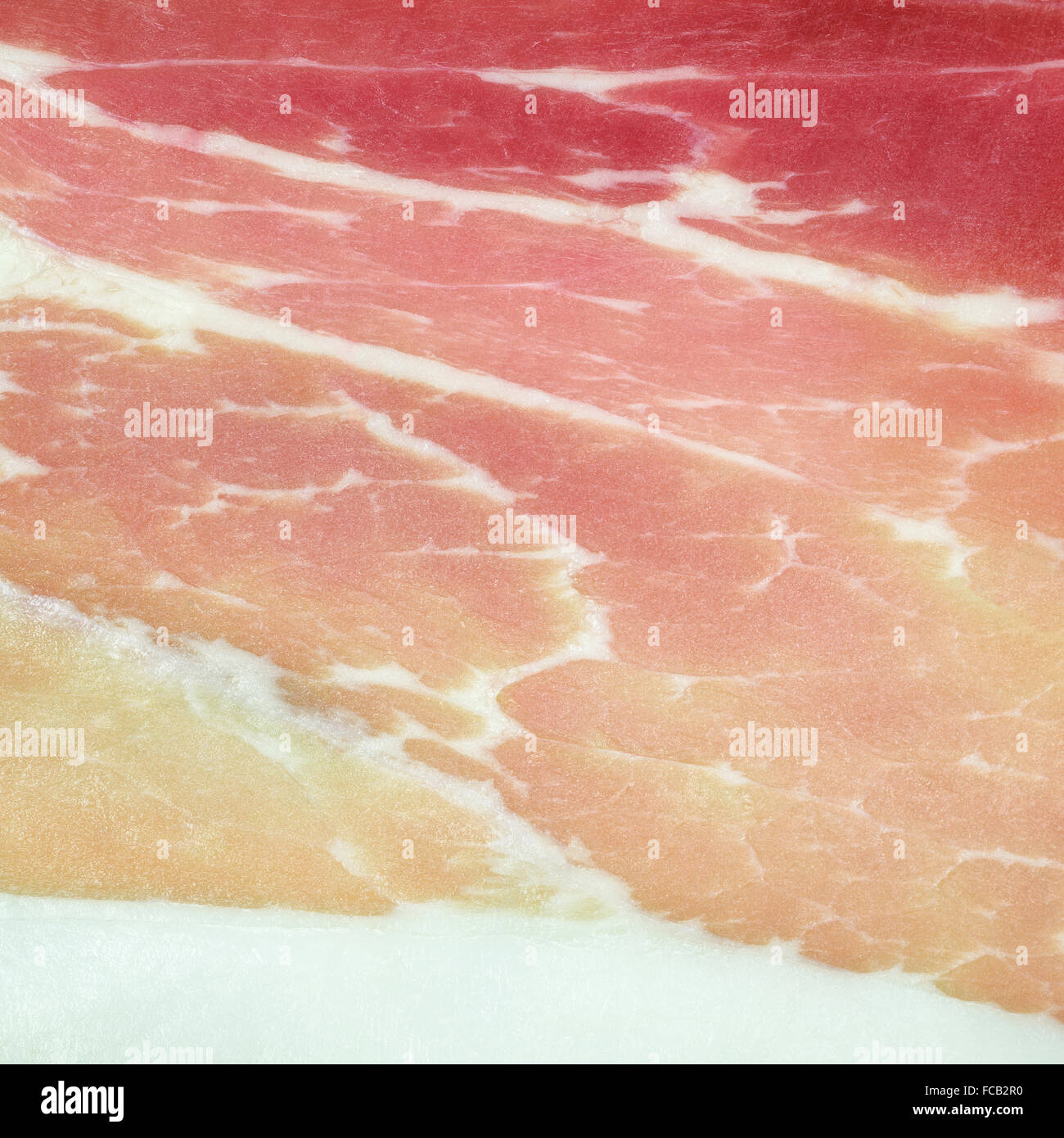 Italian pork ham Prosciutto or cold cut background texture close up. Prosciutto ham is a staple food product of Italy. Stock Photo