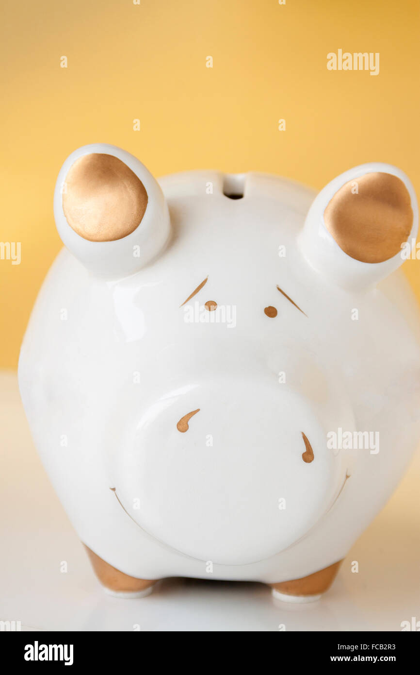 A white and gold piggy bank on a white and gold background Stock Photo ...