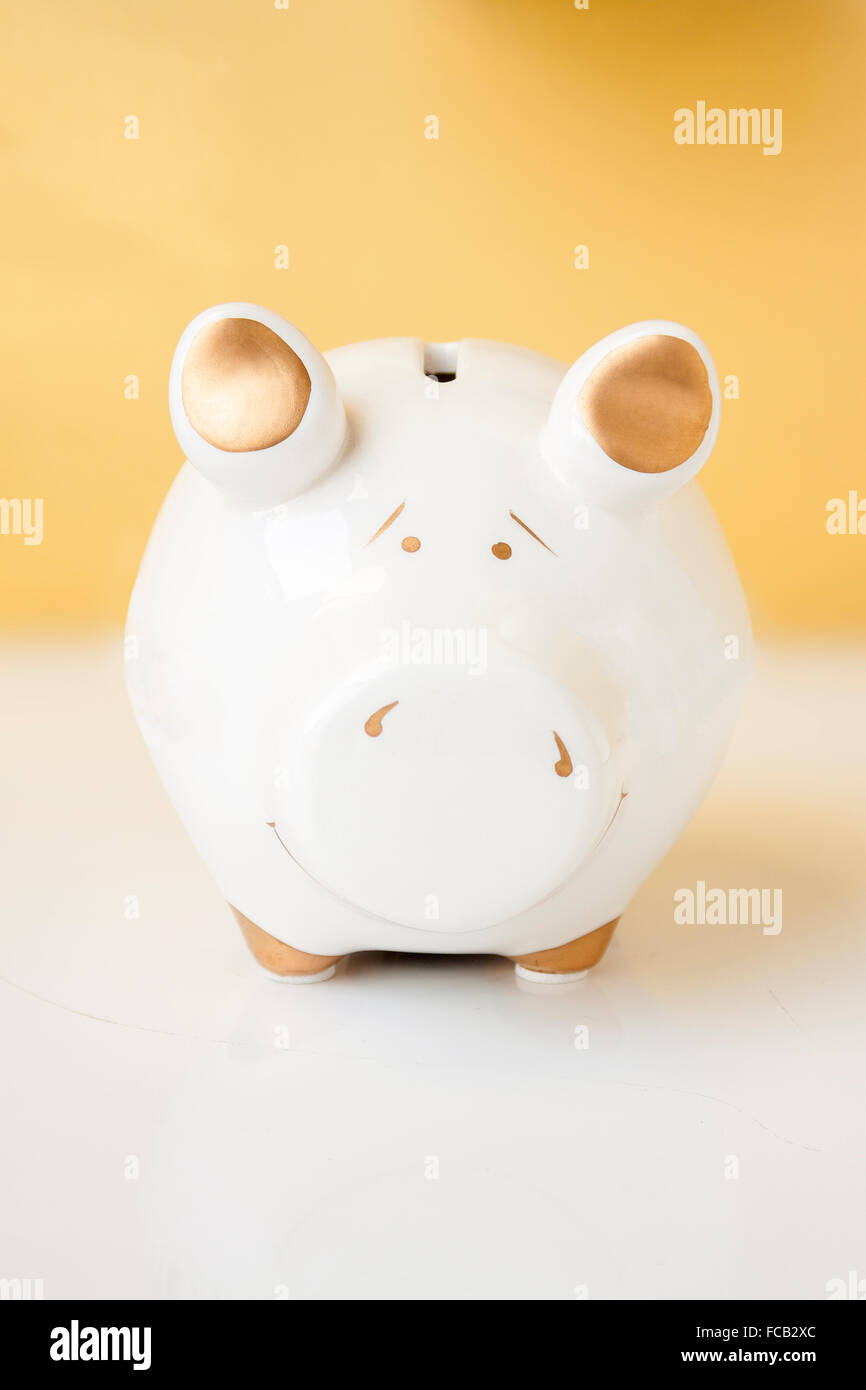A white and gold piggy bank on a white and gold background Stock Photo ...