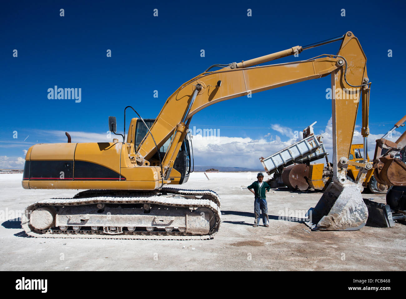 Workers with heavy machinery in the Salar de Uyuni on a hot day. The Salar de Uyuni is the largest salt flat in the world and Stock Photo