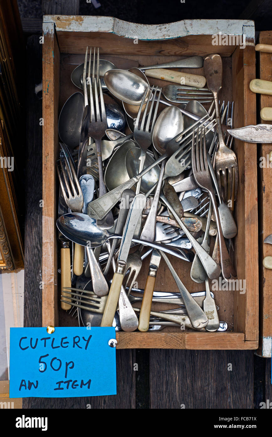 Boxes of cheap, secondhand cutlery for sale on a market stall in