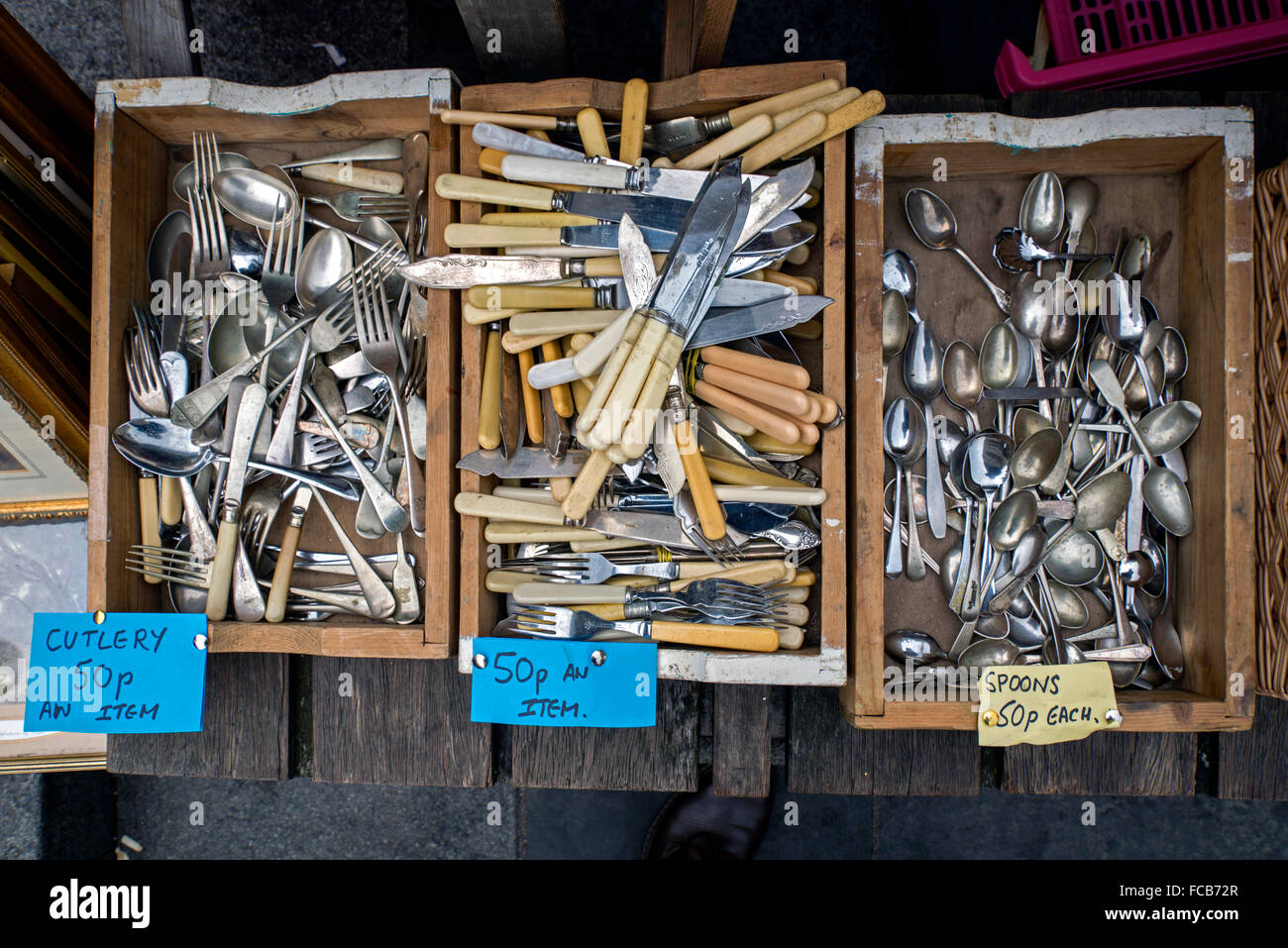 Boxes of cheap, secondhand cutlery for sale on a market stall in Edinburgh's Grassmarket. Stock Photo