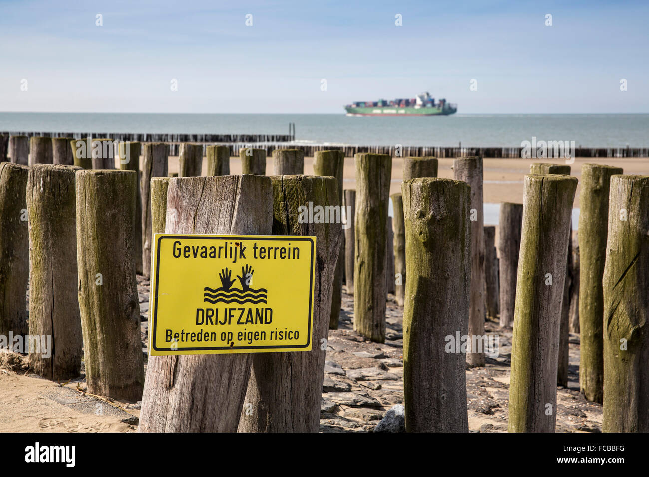 Netherlands, Breskens, Wooden poles as breakwater to protect against waves of North Sea. Danger, quicksand Stock Photo
