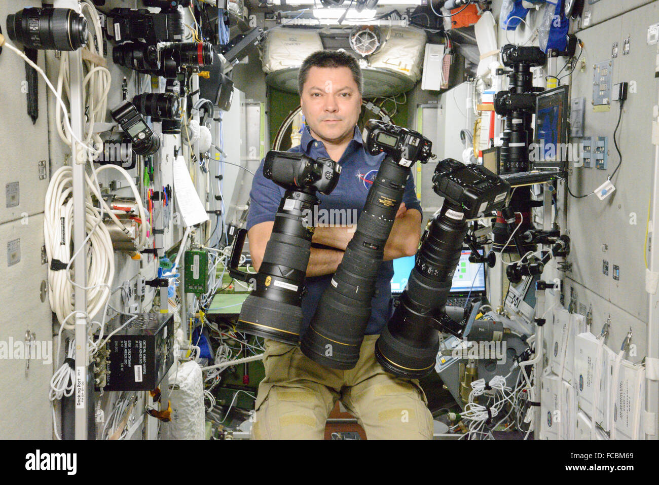 Russian cosmonaut Oleg Kononenko poses with a variety of photography equipment aboard the International Space Station October 6, 2015 in Earth Orbit. International crew members have taken more than 2.5 million images throughout the over 15 years humans have been living aboard the orbiting laboratory. Stock Photo