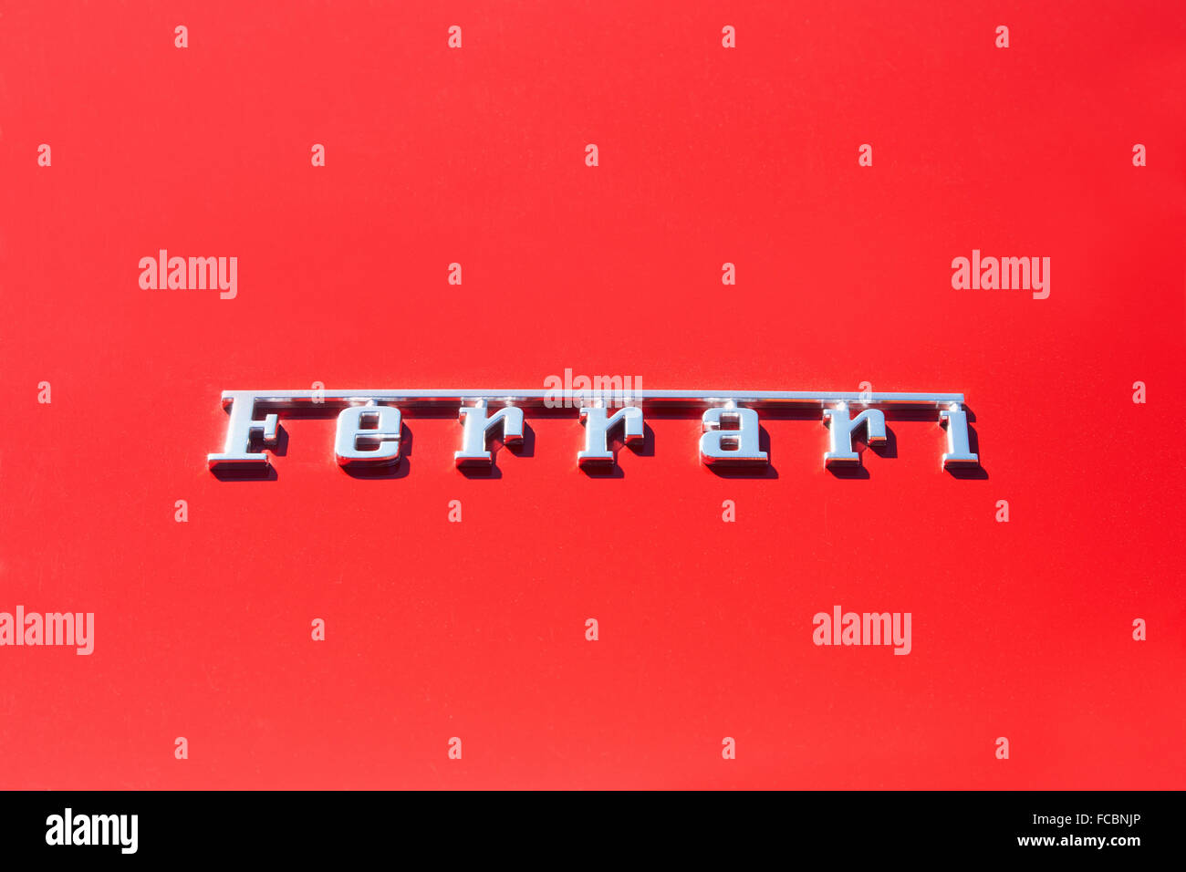 Silver Ferrari logo on red metal car body Stock Photo