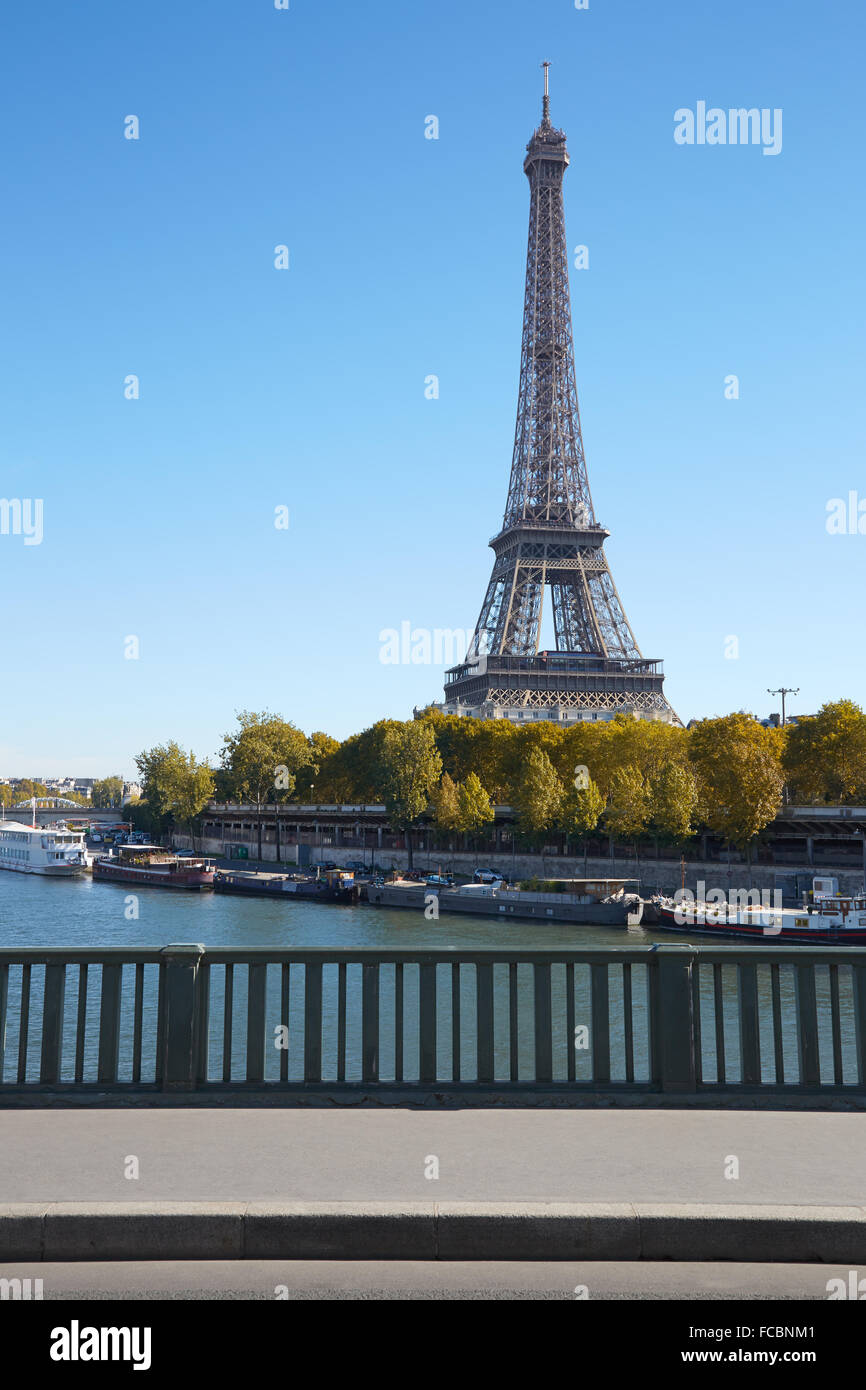 Eiffel tower and empty sidewalk bridge on Seine river in a clear sunny day, autumn in Paris Stock Photo