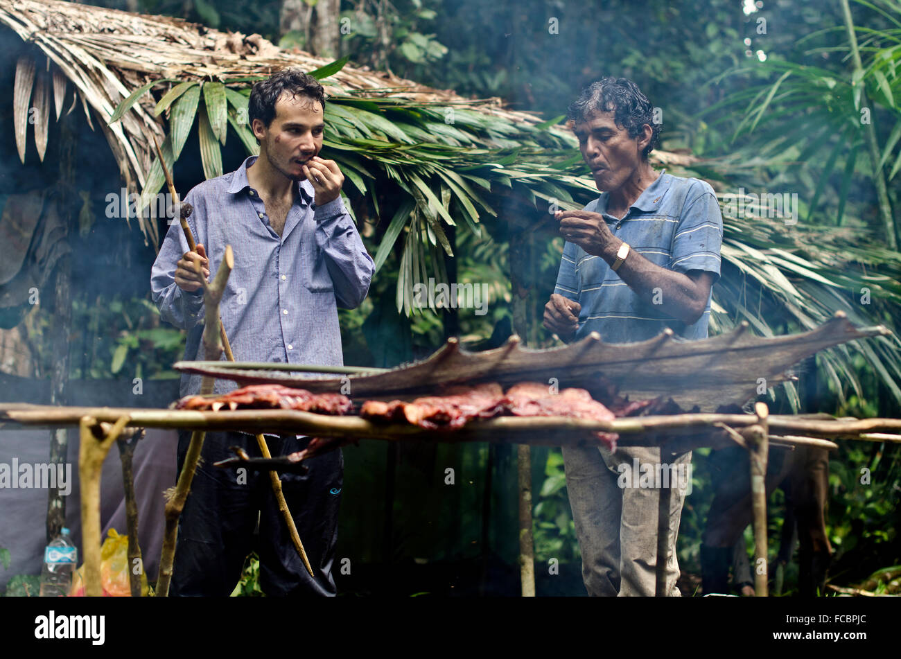Hunter and tourist  in Amazon forest  eating wild meat ,Iquitos, Peru Stock Photo