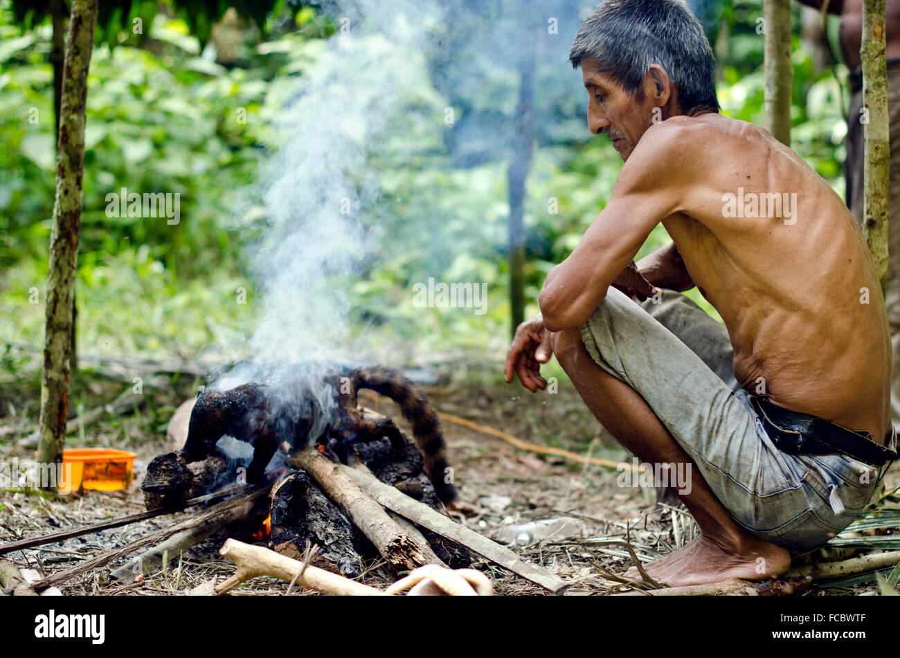 Shaman and hunter cooking his prey in Amazon ,forest ,Iquitos, Peru Stock Photo