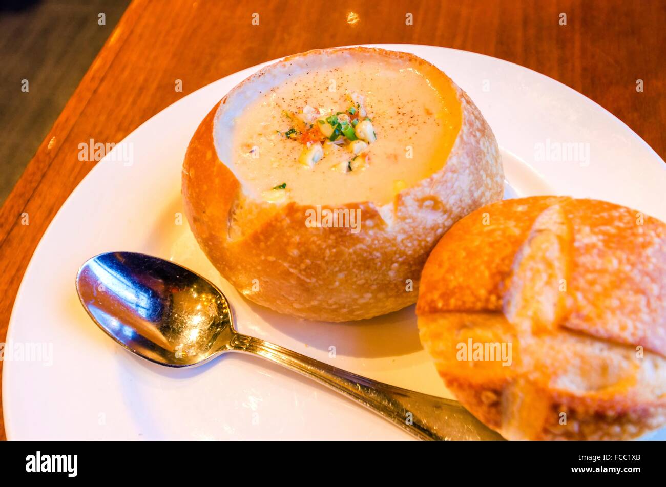 Close up of a Sourdough Clam Chowder gourmet dish. A creamy soup made of clams and vegetables served in a loaf of bread by remov Stock Photo