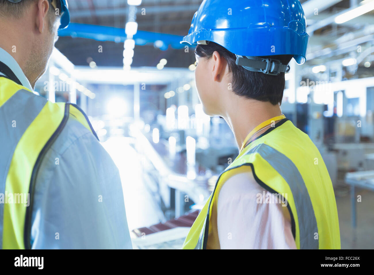 Workers in reflective clothing and hard-hat in factory Stock Photo