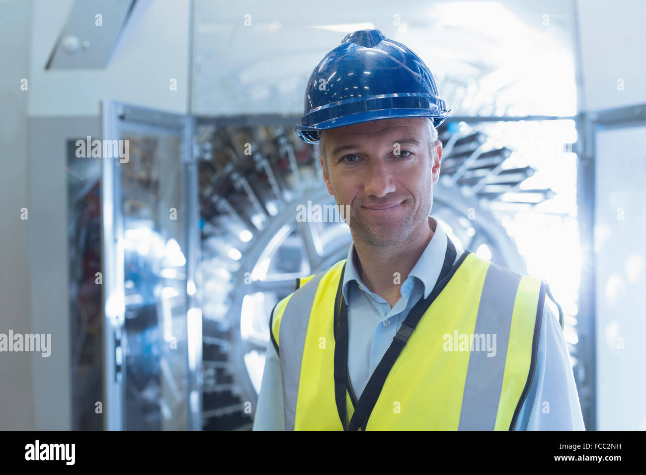 Portrait confident worker in reflective clothing and hard-hat in factory Stock Photo