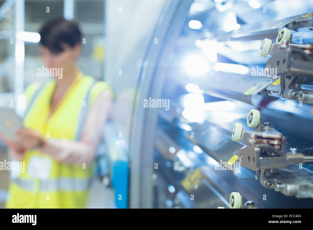 Worker behind machinery in factory Stock Photo