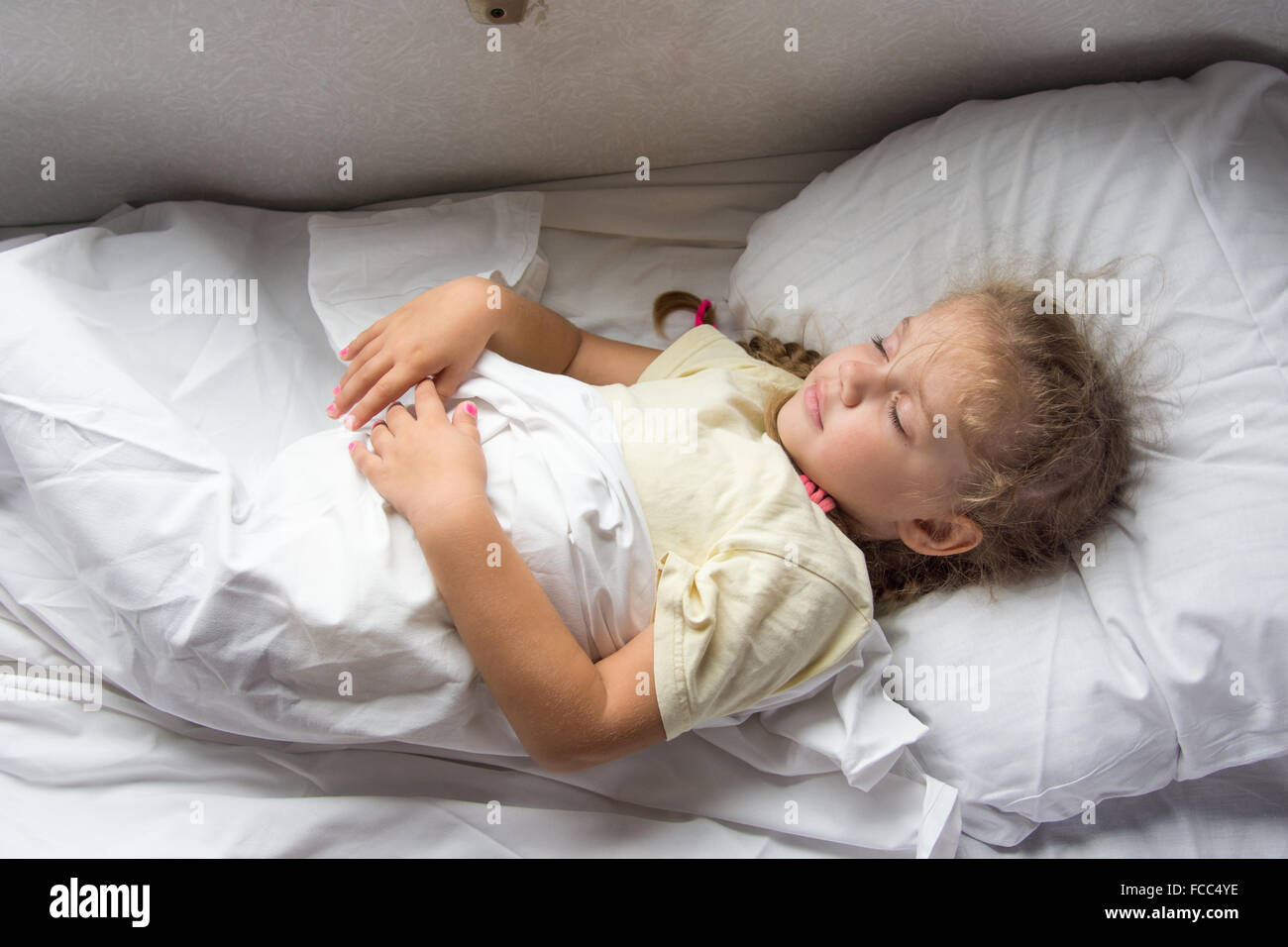 Fouryear girl sleeping on a cot in a secondclass train carriage Stock