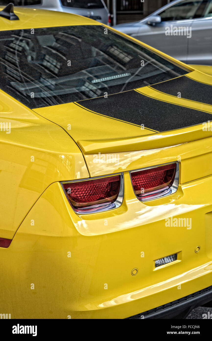 2010 Yellow Chevrolet Camaro, Black Stripe Trim, Parked on a Manhattan, New York City Street.  Rear View. Stock Photo