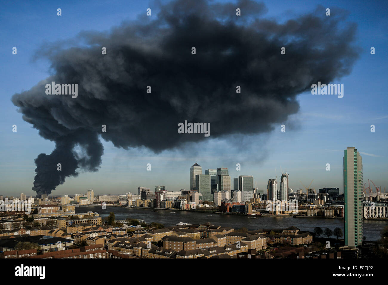 Black smoke cloud seen over Canary Wharf from a warehouse fire in east London, UK. Stock Photo