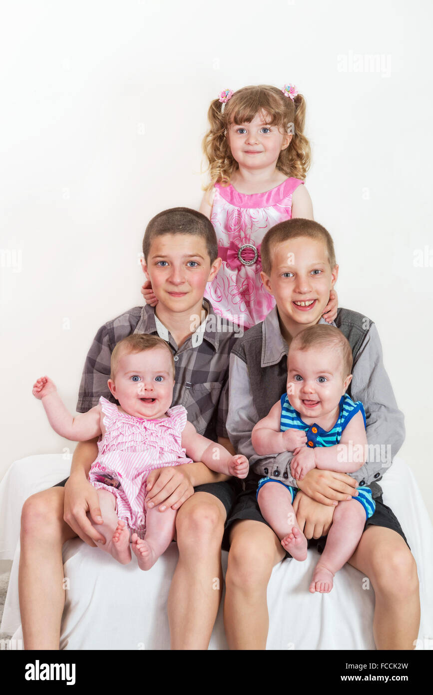Studio portrait of happy family - brothers and sisters different ages on light background Stock Photo
