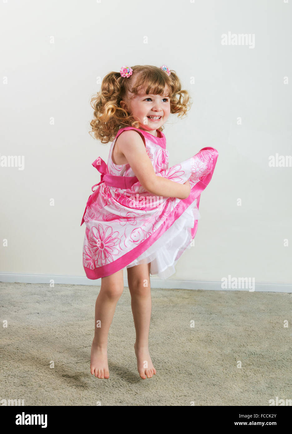 Portrait of cute little girl jumping of joy  on the floor Stock Photo