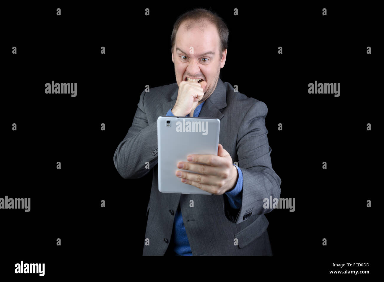 young man dark gray suit angry holding tablet Stock Photo