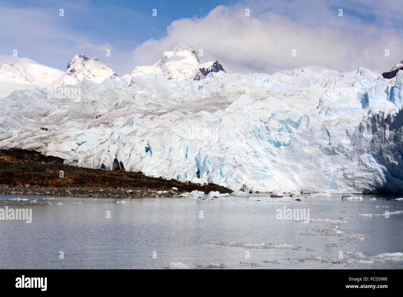 Remote Tourists In An Extreme Route On Glacial Mountains Stock Photo