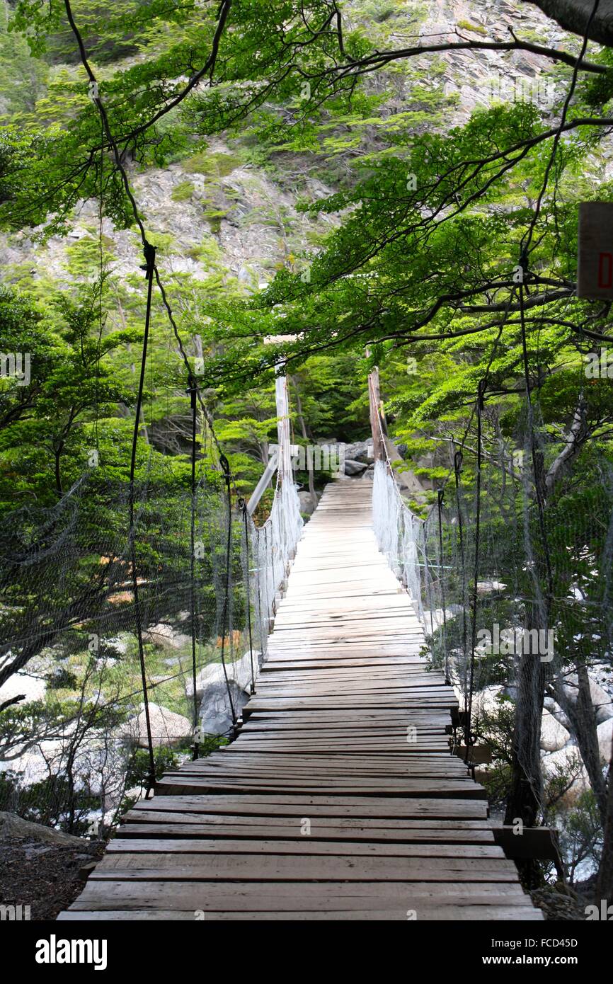 Wooden Hanging Bridge Over A River Stock Photo