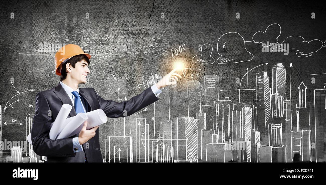 Young man engineer in helmet drawing construction project Stock Photo ...