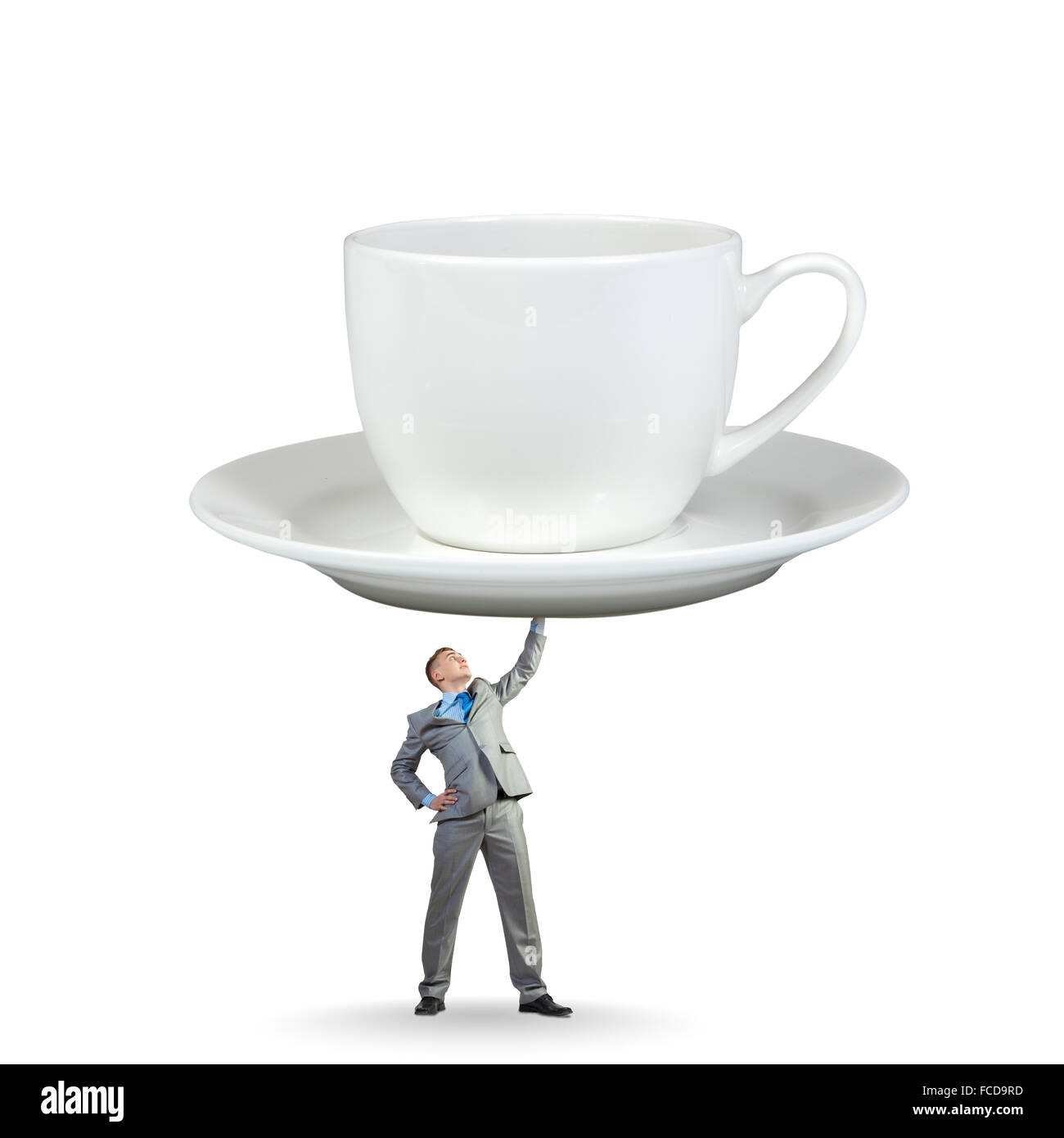 Young businessman lifting huge cup of coffee with one hand Stock Photo