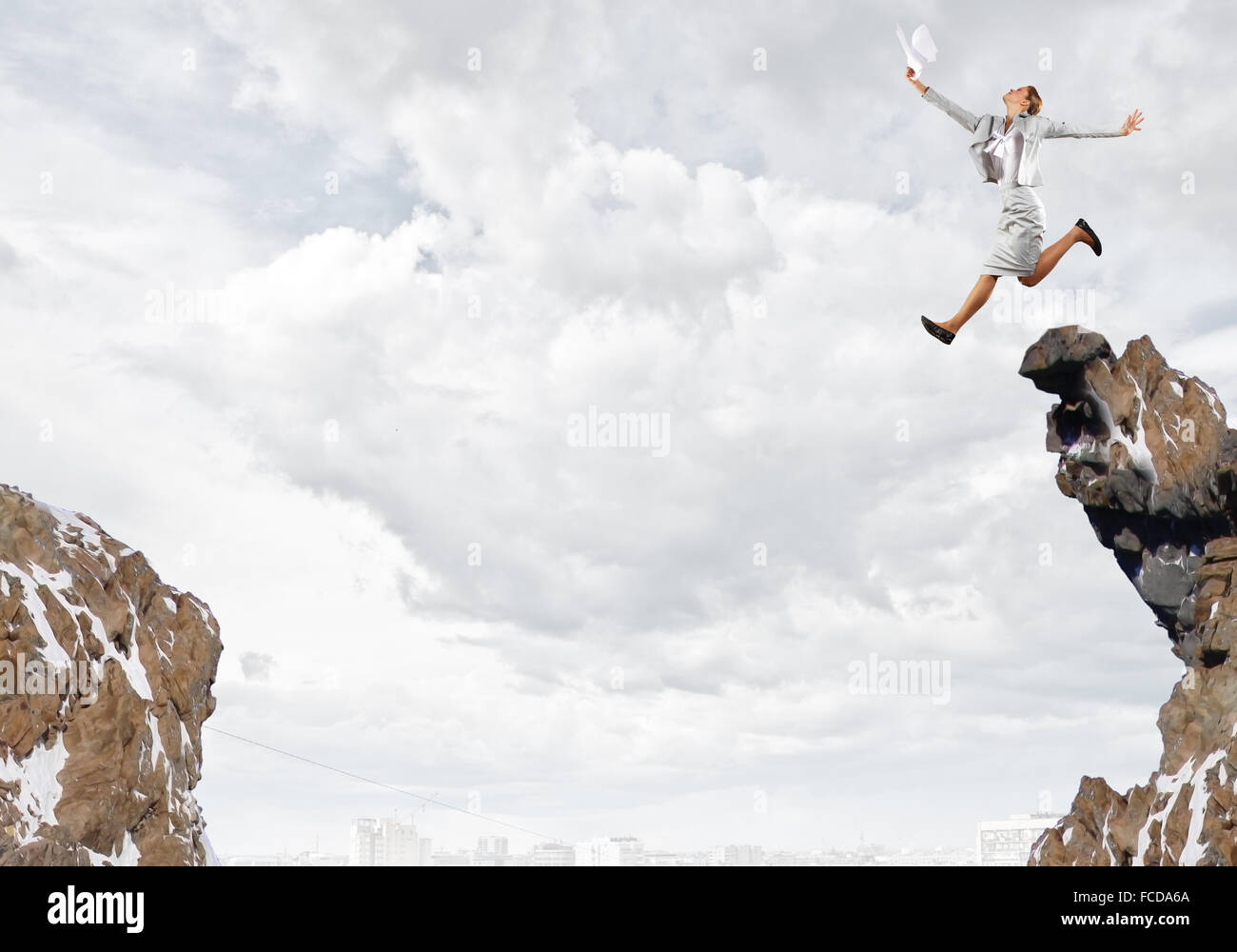 Young businesswoman jumping over gap. Risk concept Stock Photo - Alamy