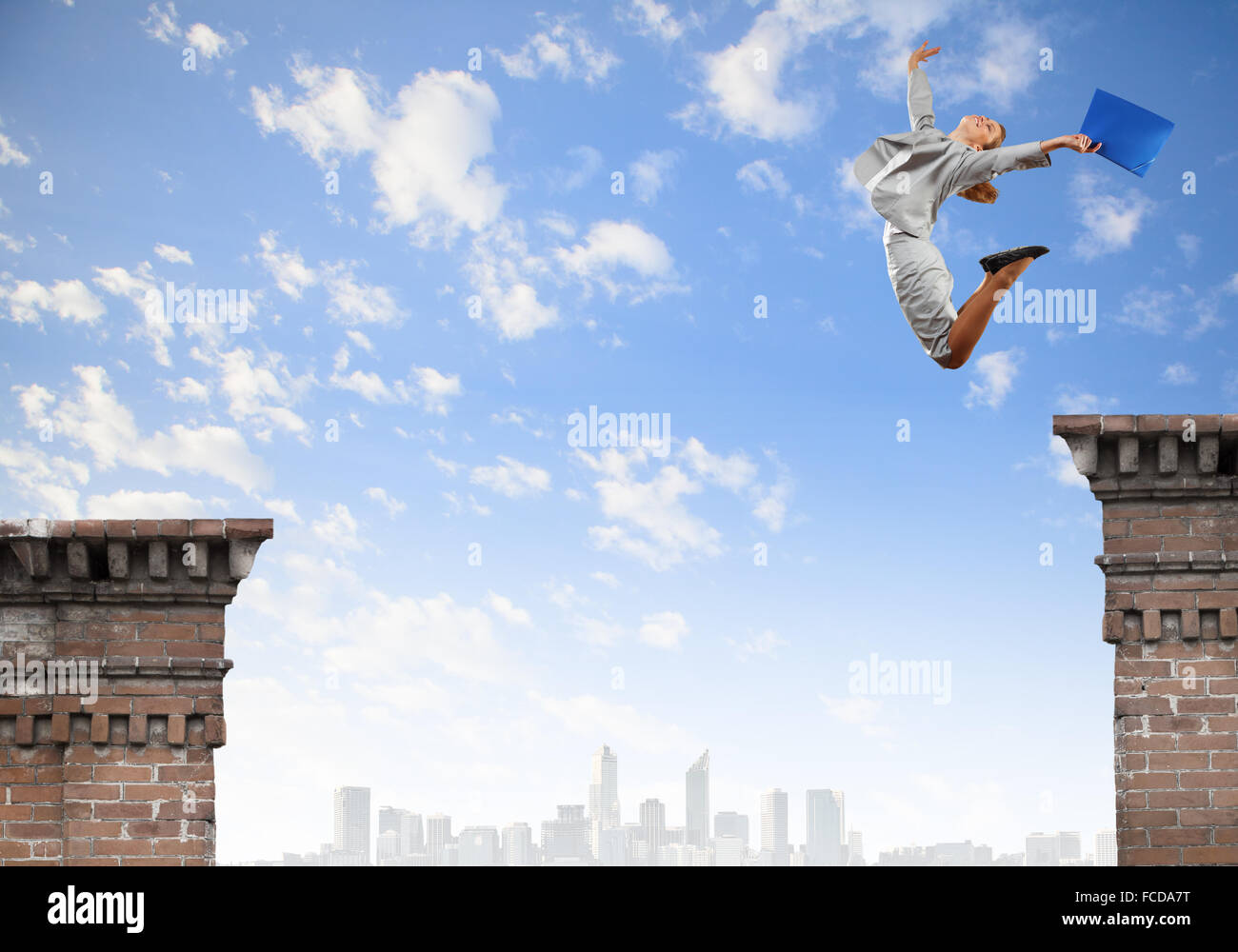 Young businesswoman jumping over gap. Risk concept Stock Photo - Alamy