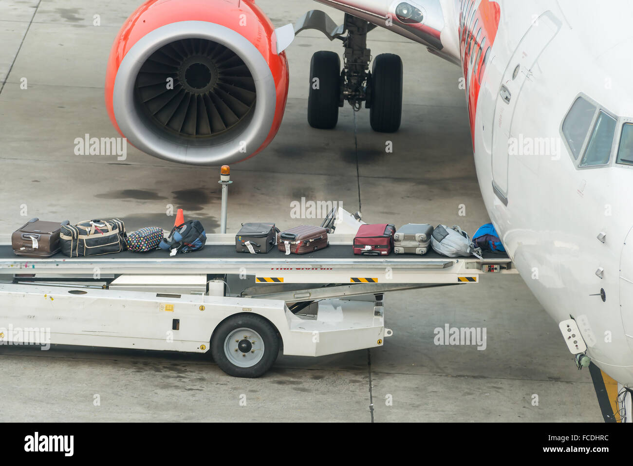 Luggage loading into a plane in an airport Stock Photo