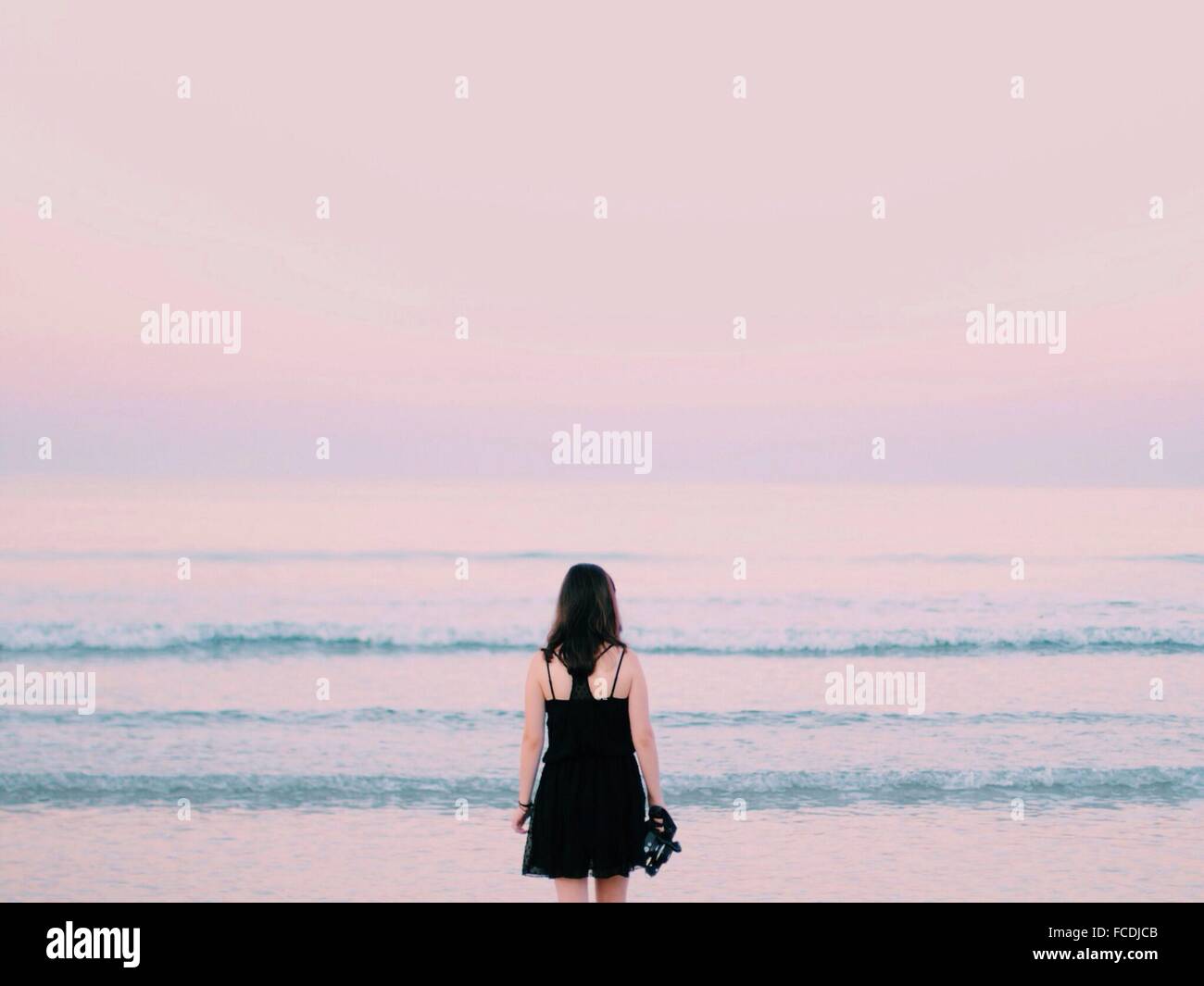 Rear View Of Woman Overlooking Calm Sea Stock Photo